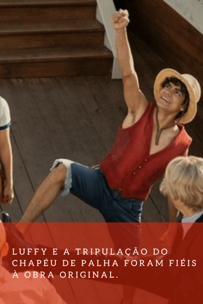 Luffy, de camisa vermelha, bermuda azul e chapéu de palha, comemorando.